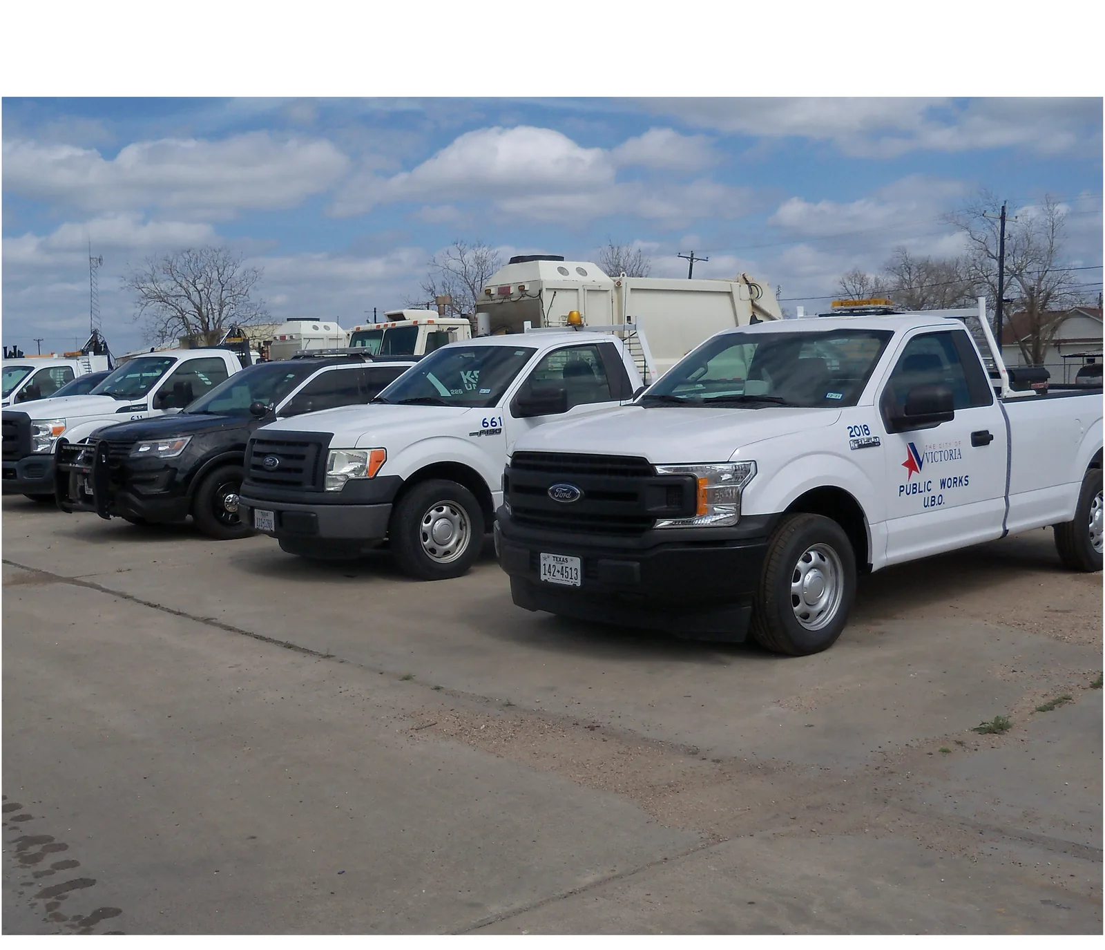 Municipal public works trucks staged in a lot