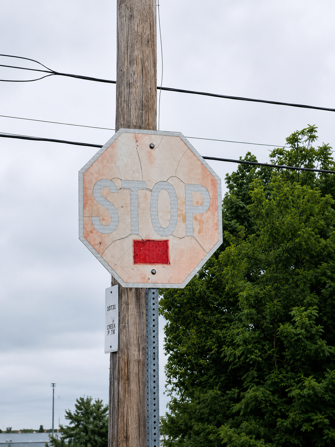 A stop sign with severely faded and cracked reflective sheeting